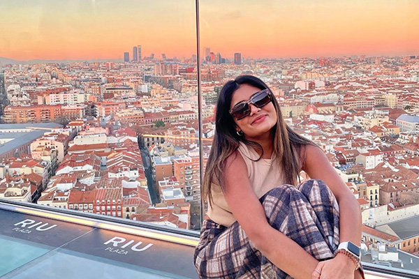 Student on a Learning Abroad Center program poses with the skyline of Madrid